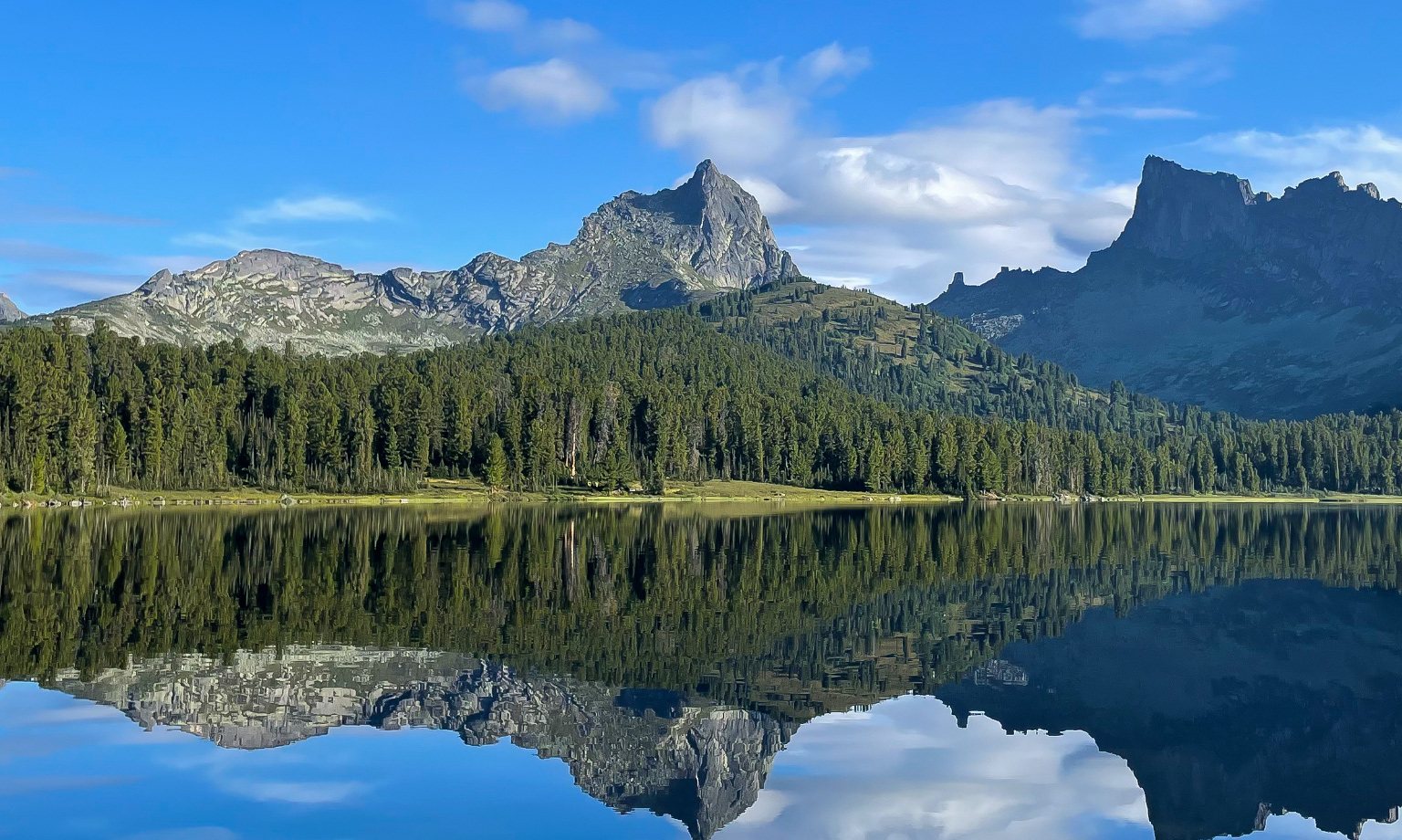 mountains and trees reflecting in a lake