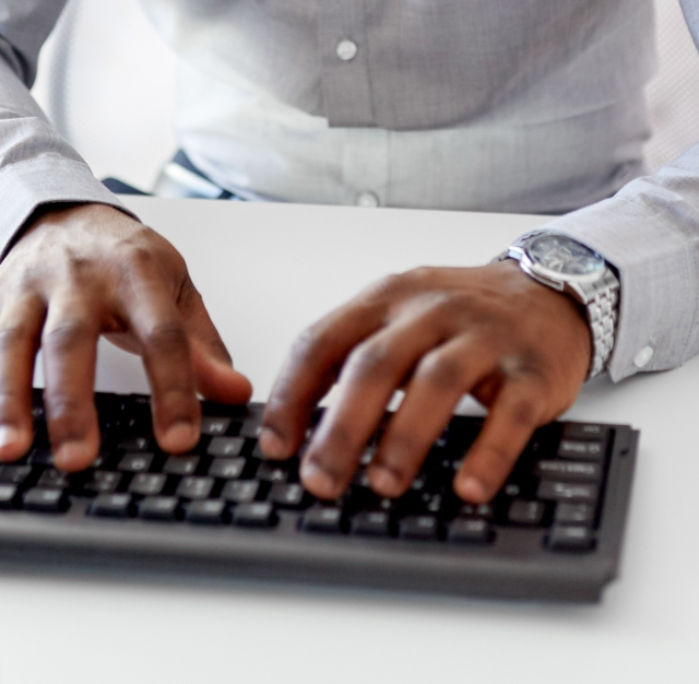 Man's hands typing on a keyboard